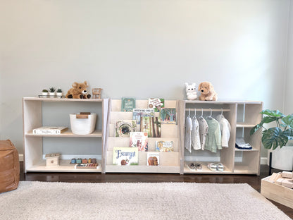 Children's Montessori style bedroom storage system with toy shelf, book shelf, and clothing wardrobe in light natural birch.