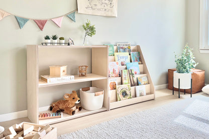 Child's Montessori bookshelf in natural birch next to toy storage shelf.