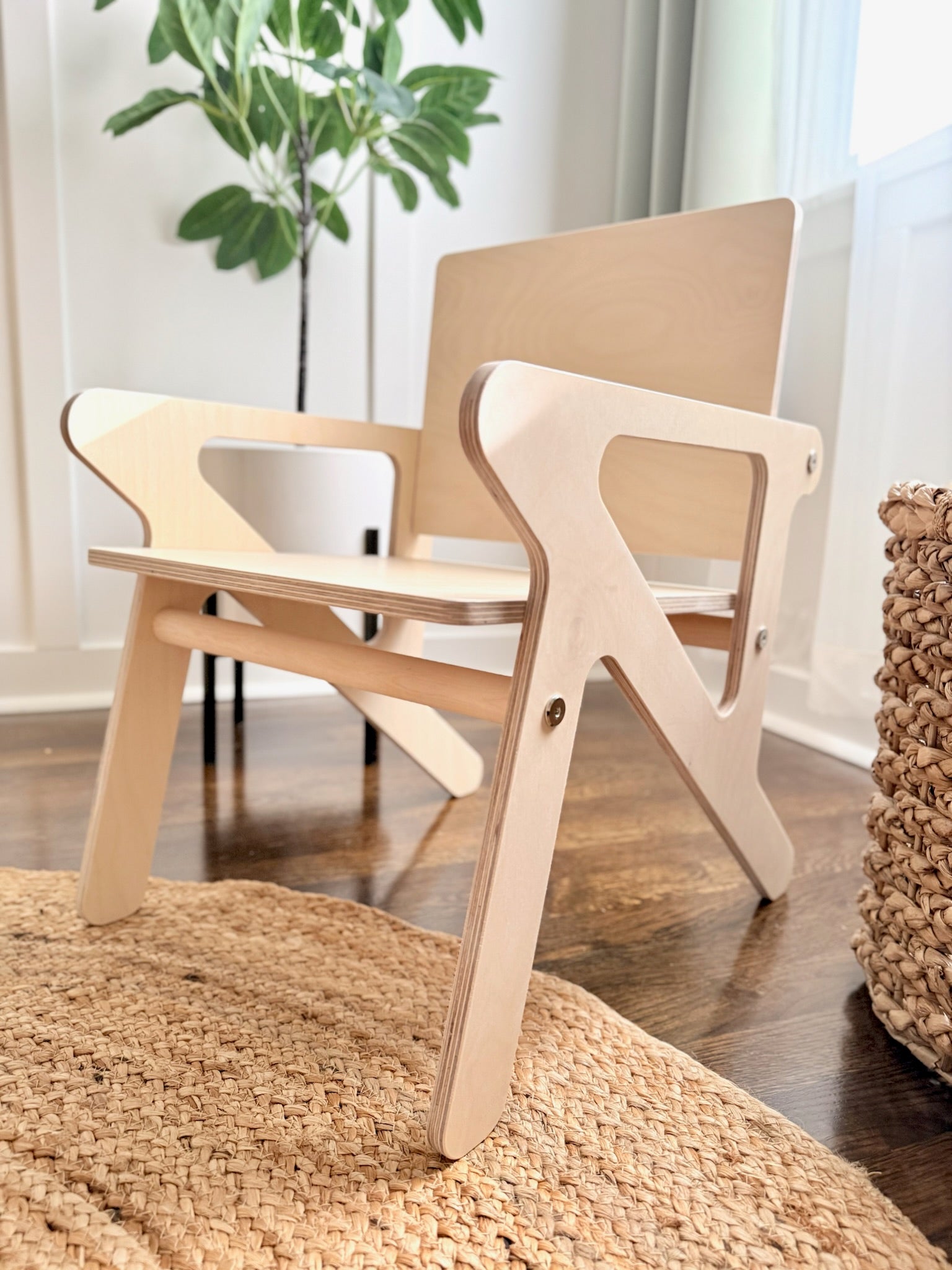 Wooden mid century modern child's toddler chair in a room with a plant and rug