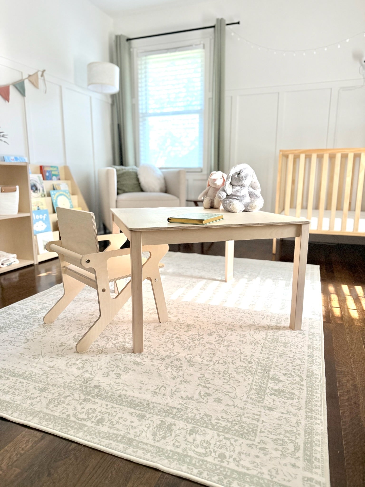 Children's playroom with a wooden table and chairs on a light rug.