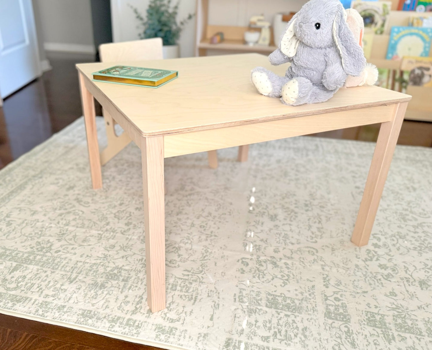 Children's birch wooden table with a plush toy on a rug