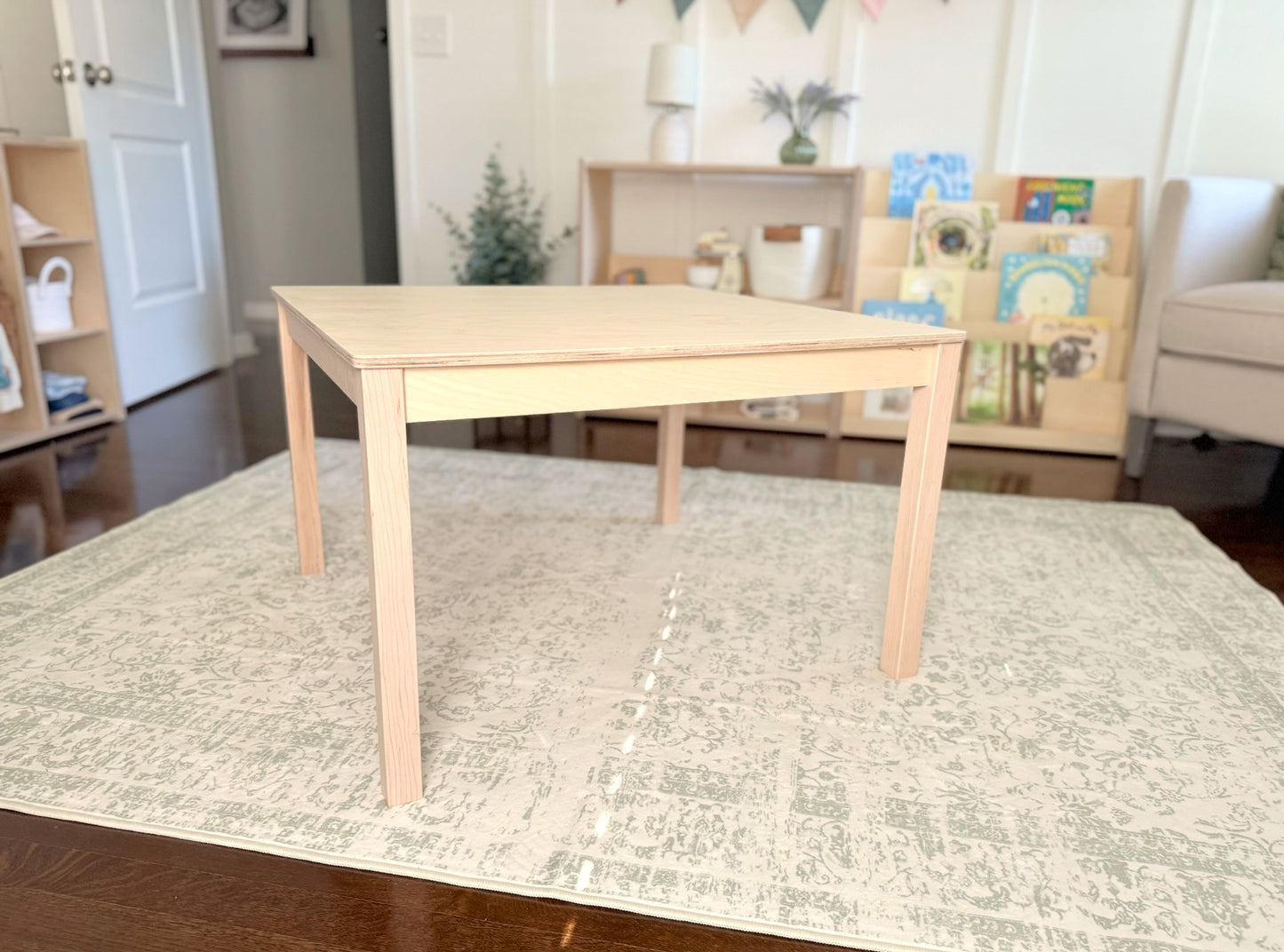 Wooden childrens montessori table in a room with a rug and furniture