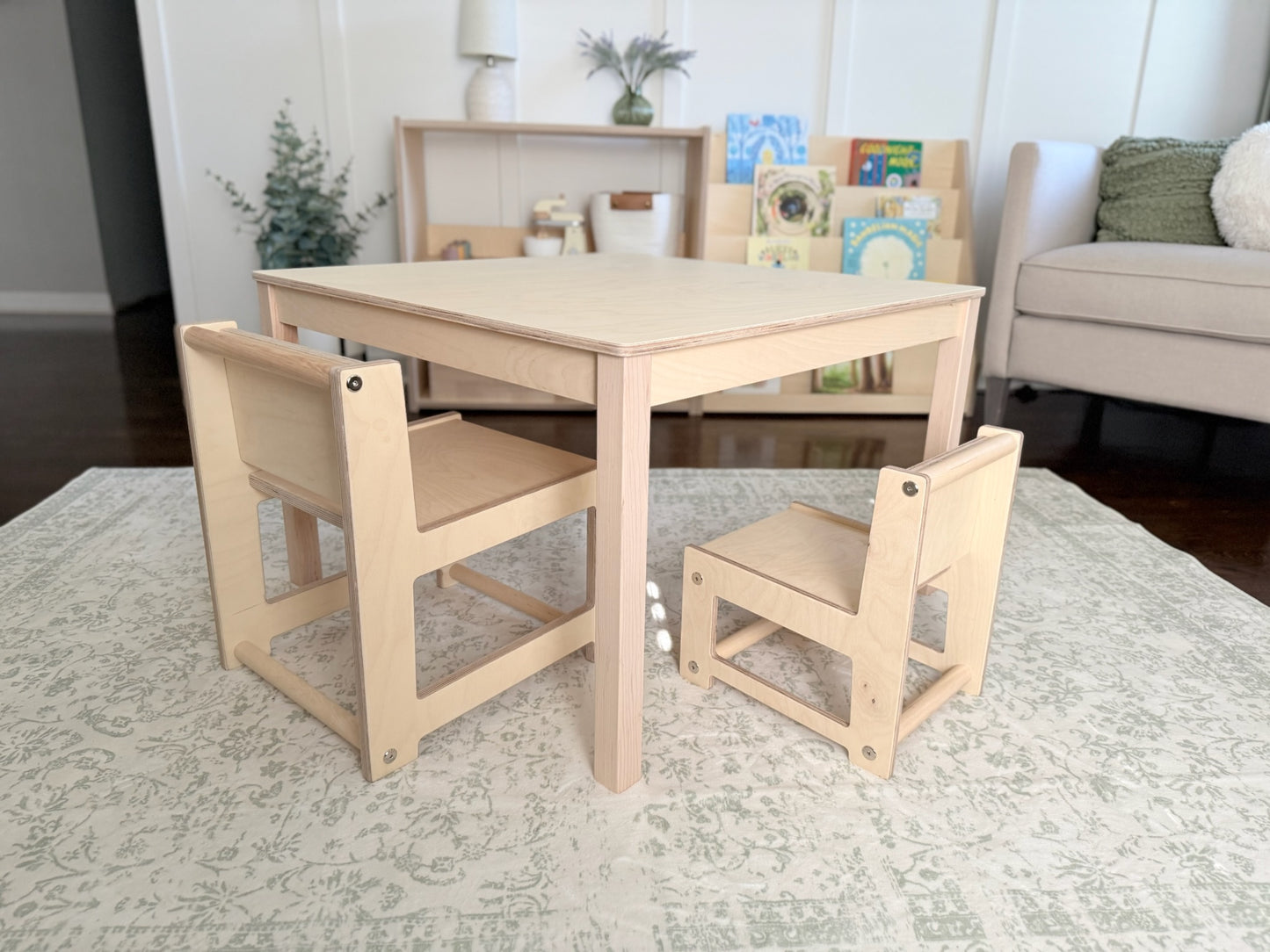 Children's wooden table and chairs set in a playroom.
